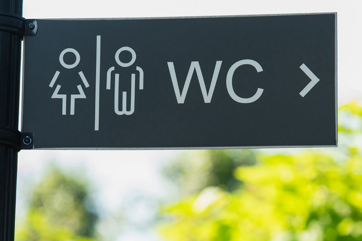 Modern unisex toilet sign in matte black ACM finish in a commercial office park